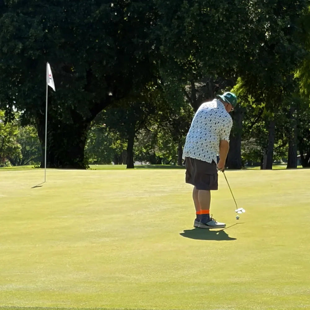 Golfer on a green putting the ball