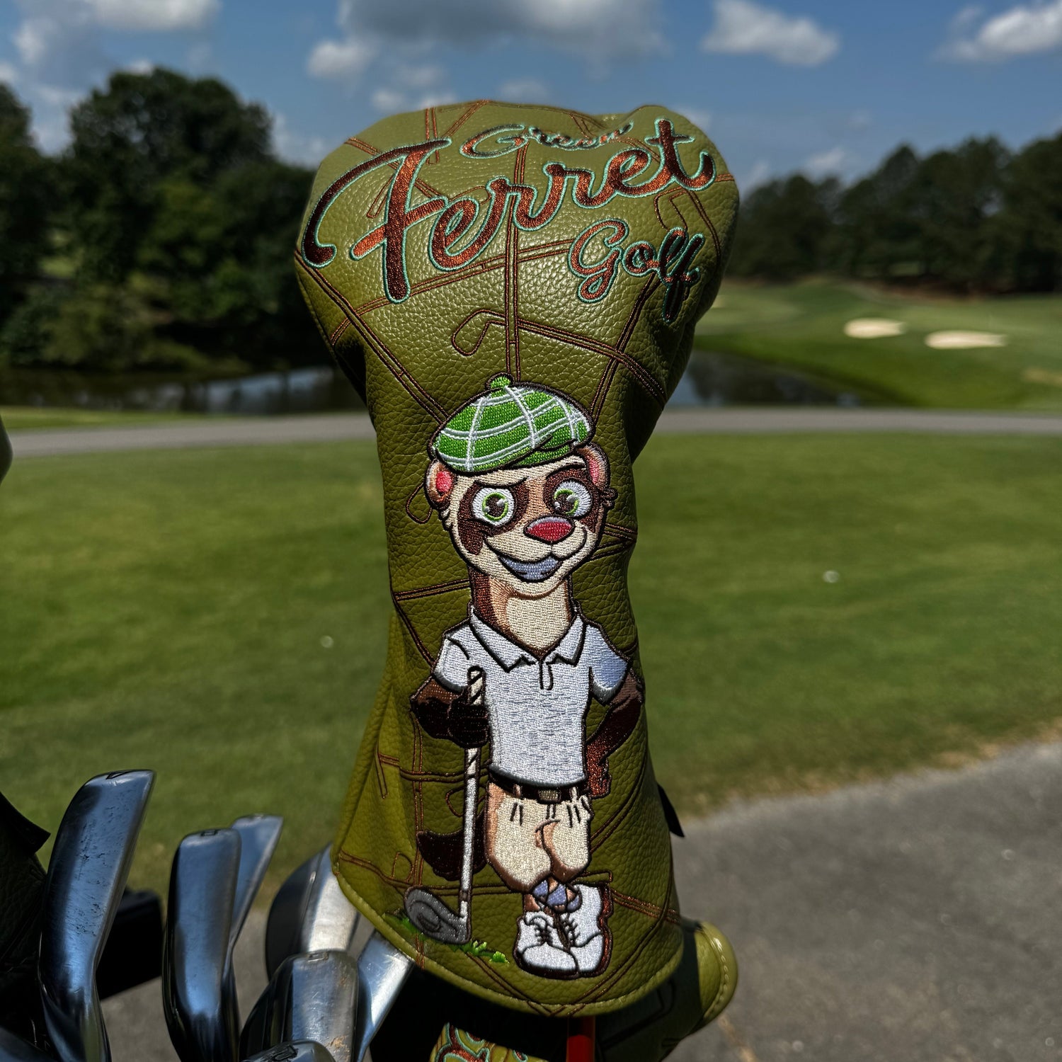 Golf club head cover with cartoon character design on a golf course background