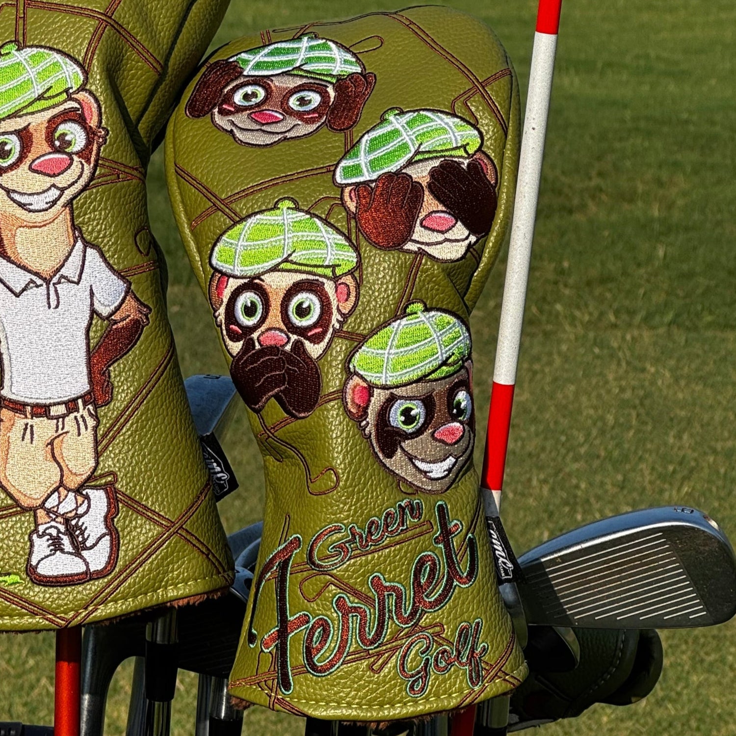 Green Ferret Golf branded Golf club with cartoon character head covers on a grassy background