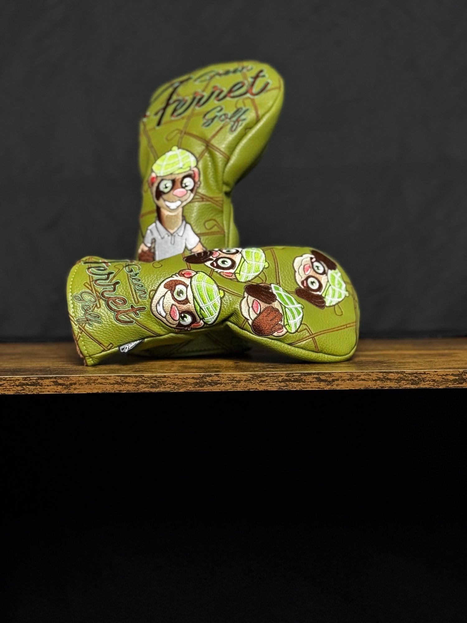 Green Ferret Golf branded golf club head cover with cartoon ferret design on a wooden surface