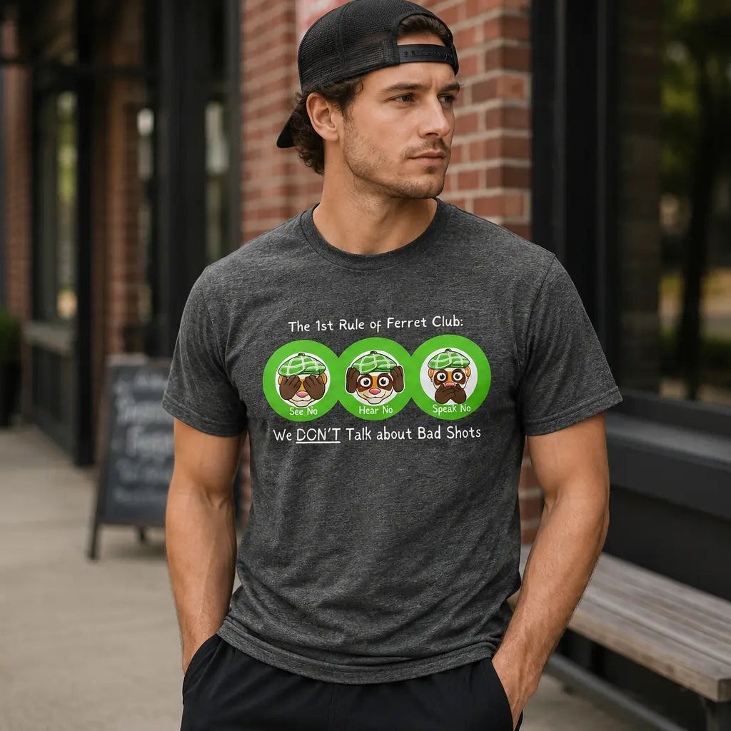 Man wearing a gray t-shirt with graphic designs and text, standing on a sidewalk.