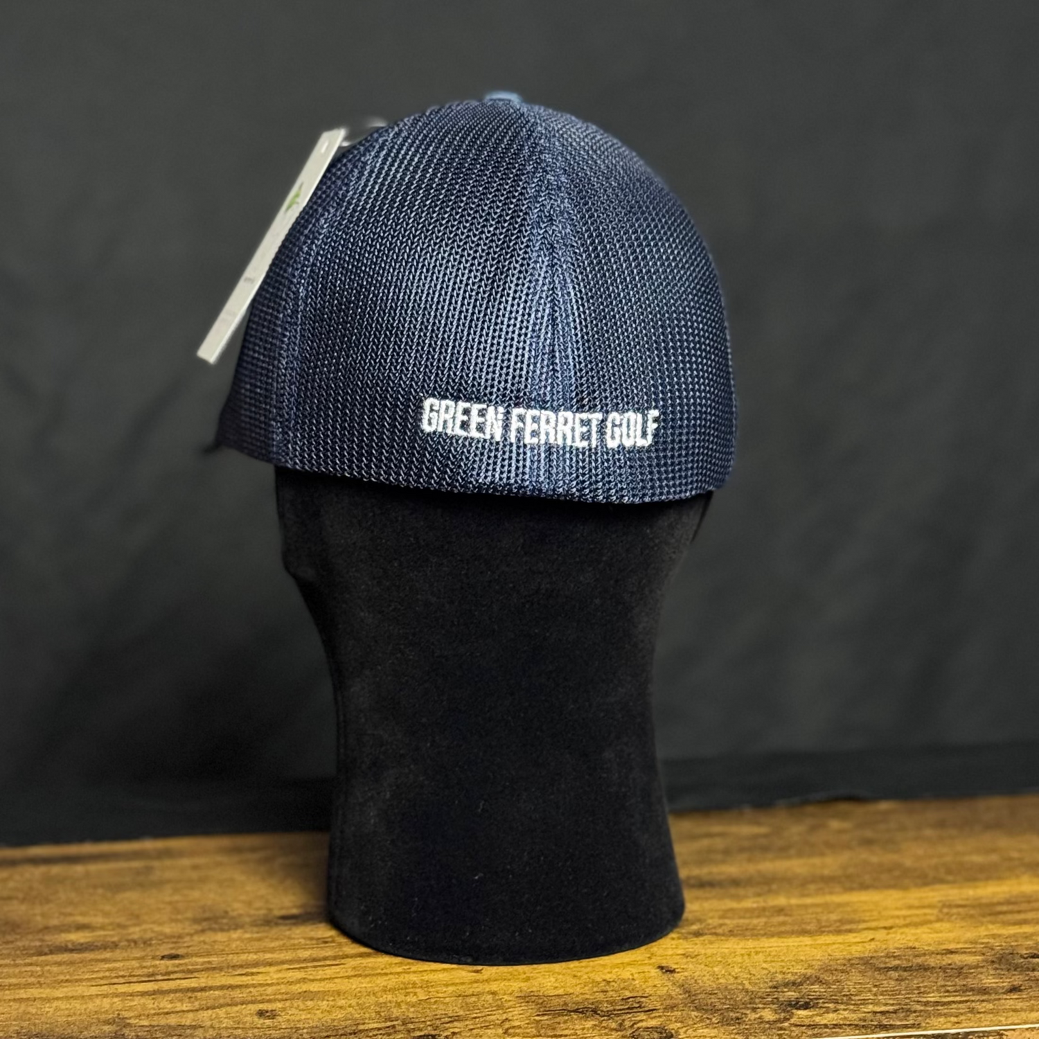 Blue golf hat with 'Green Ferret Golf' logo on a black mannequin head against a dark background