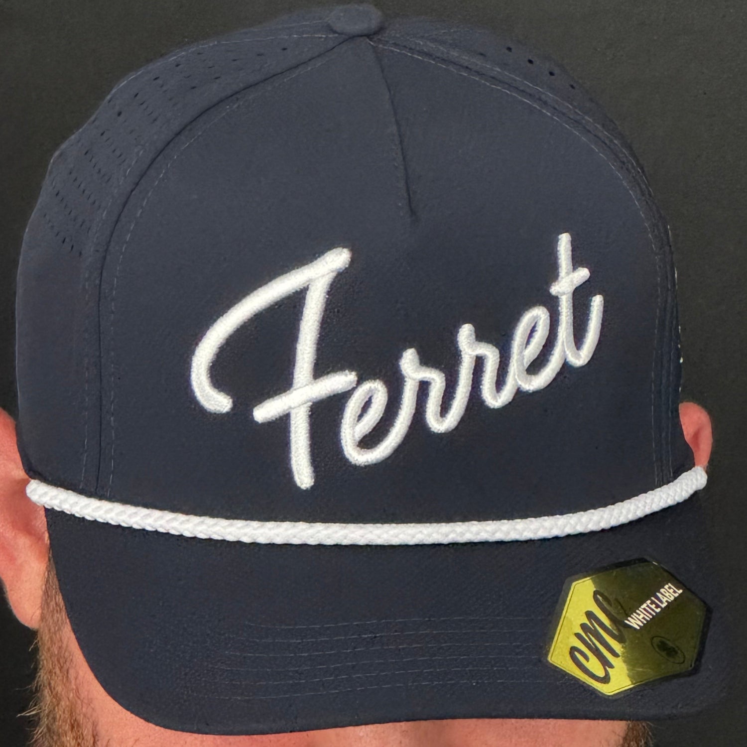 Person wearing a navy cap with 'Ferret' branding against a black background