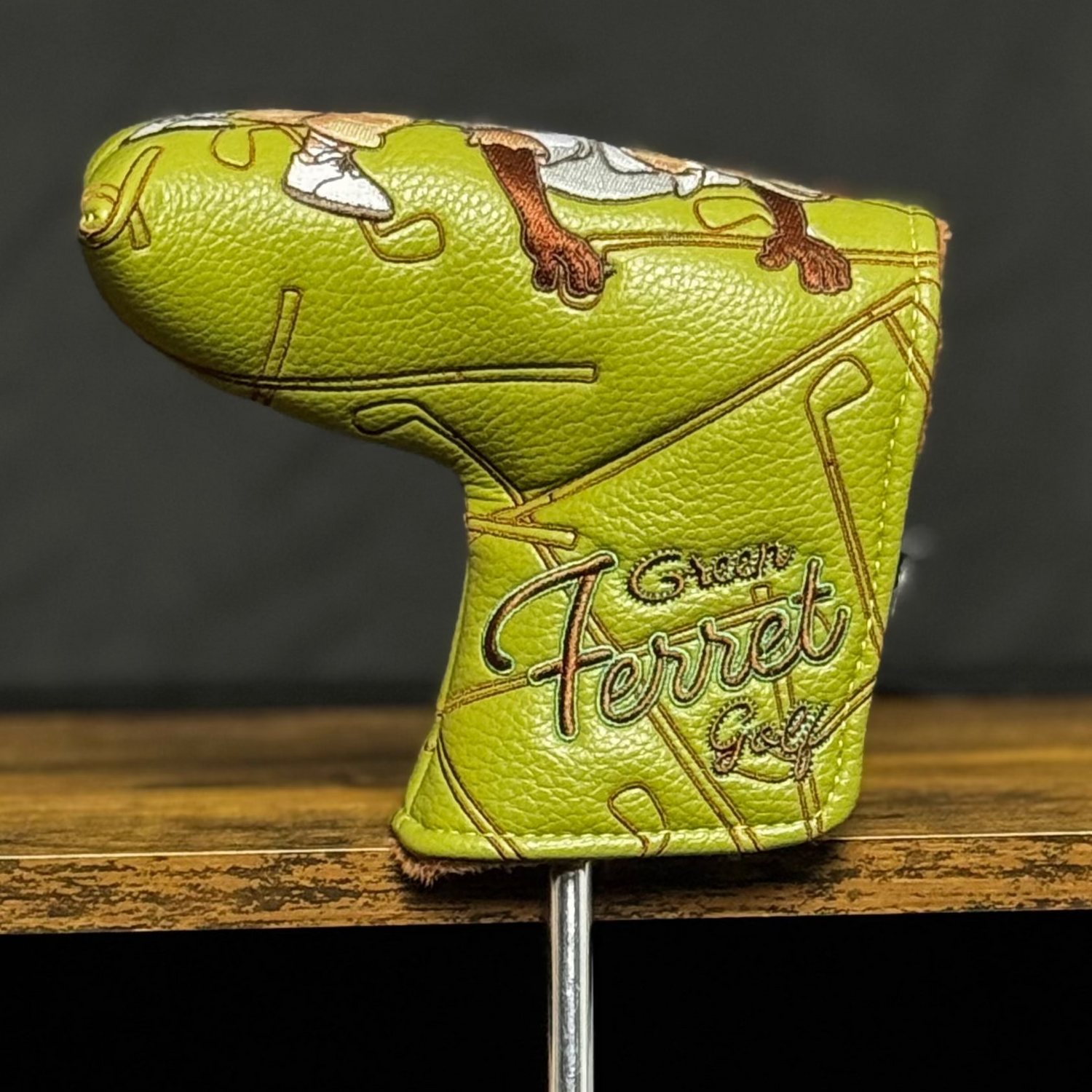 Green golf club head cover on a stand with a dark background