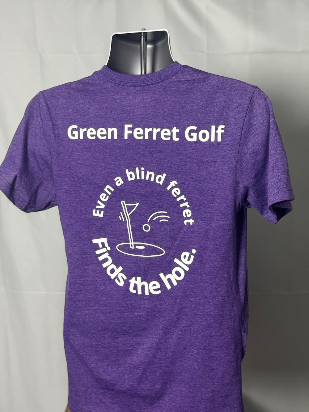 Purple t-shirt with 'Green Ferret Golf' text and graphic on a plain background