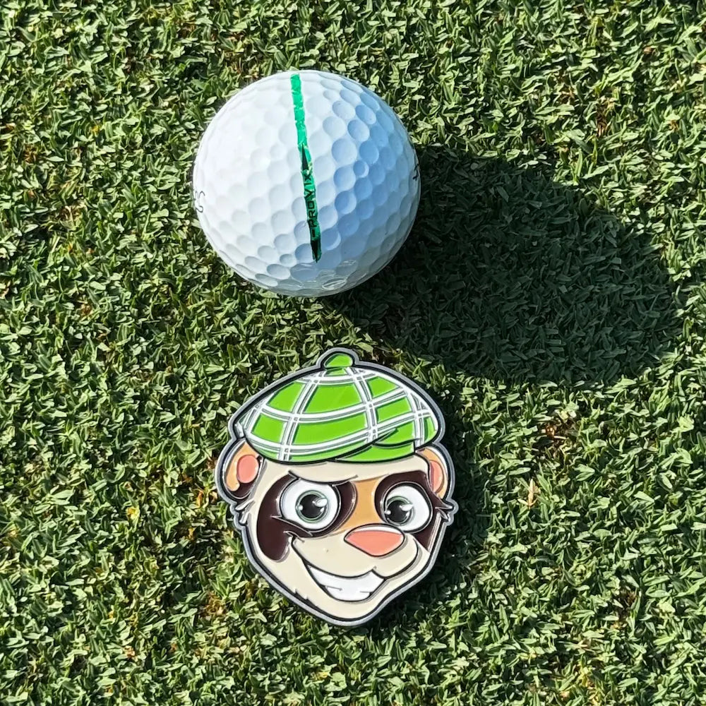 Finneus Ferret Large ball marker. Non magnetic face featuring FInneus' signature grin from Green Ferret Golf next to a titleist golf ball.