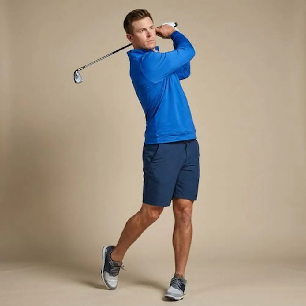Model swinging a golf club wearing a Players Quarter Zip Jacket in Royal Blue from Green Ferret Golf