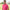 Man wearing a pink polo shirt with a logo on a blurred outdoor background