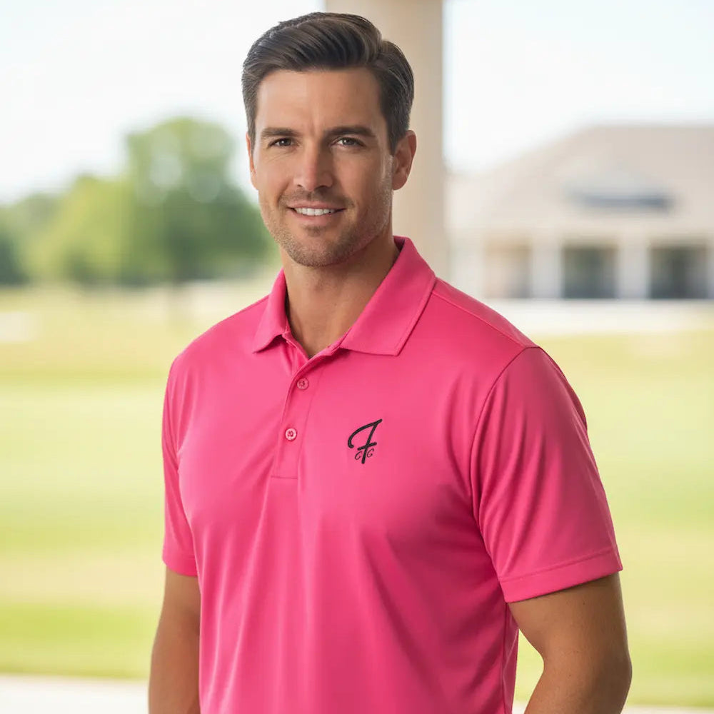 Man wearing a pink polo shirt with a logo on a blurred outdoor background