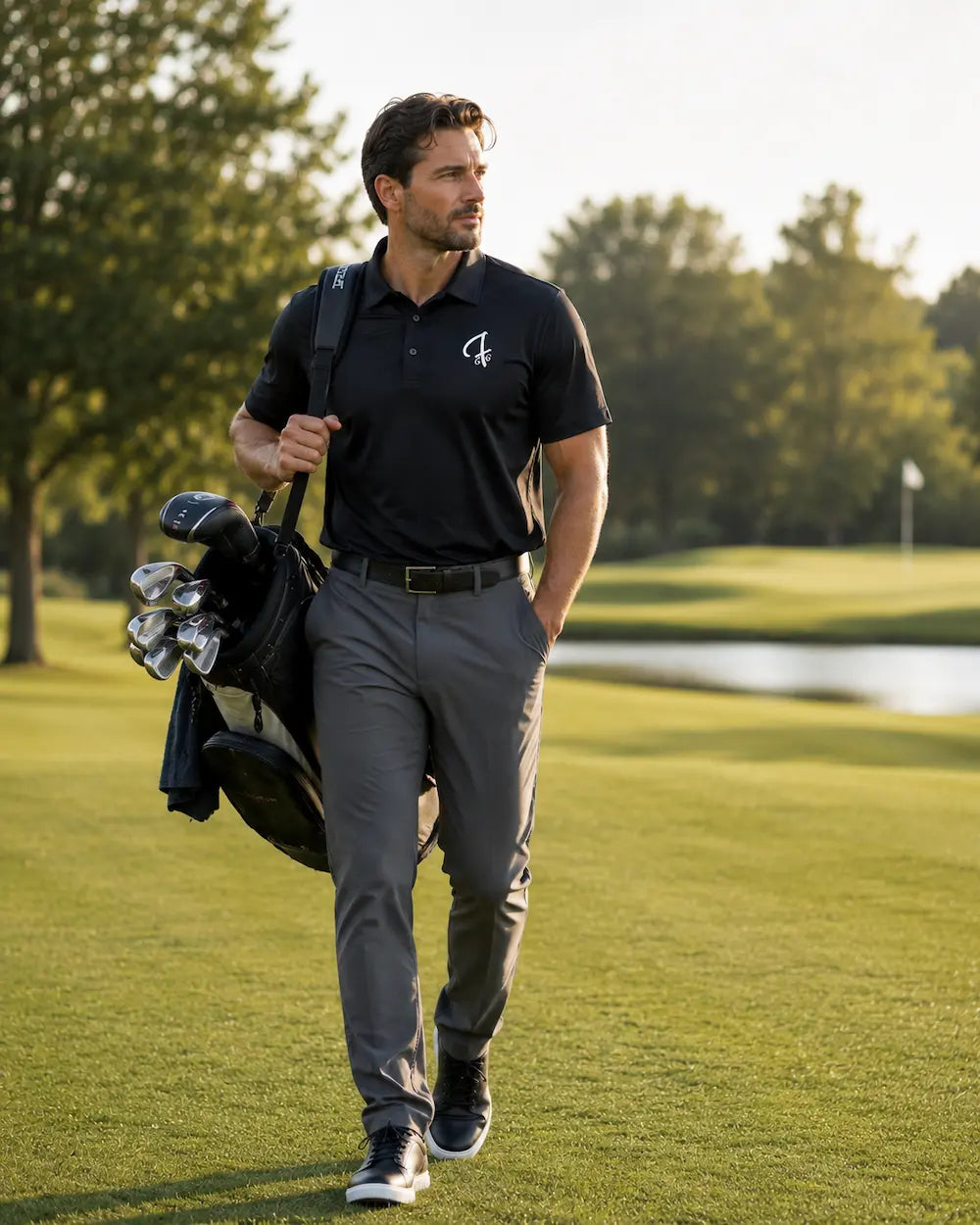 Man walking on a golf course with a Black pro shop polo from green ferret golf carrying his golf bag