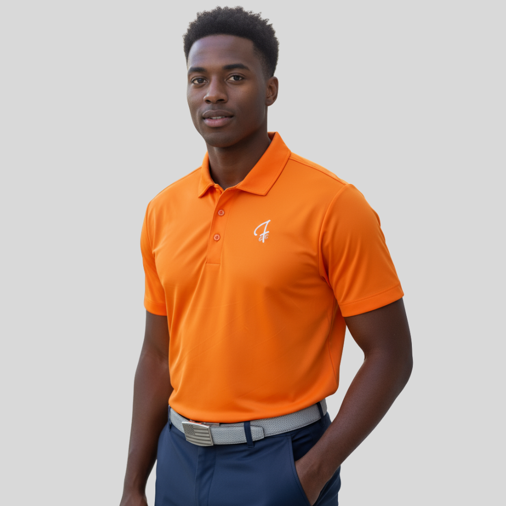 Man wearing an bright orange polo shirt with a Green Ferret Golf logo on a gray background