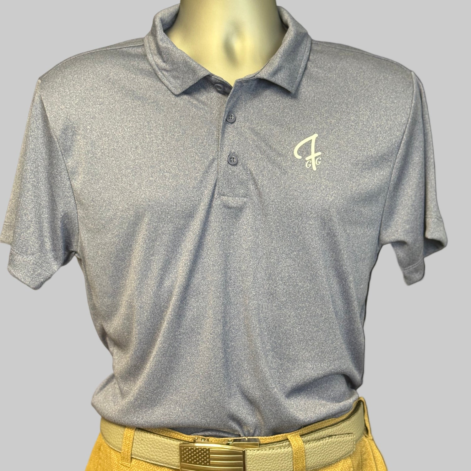 Light navy polo shirt with a logo on a mannequin against a black background