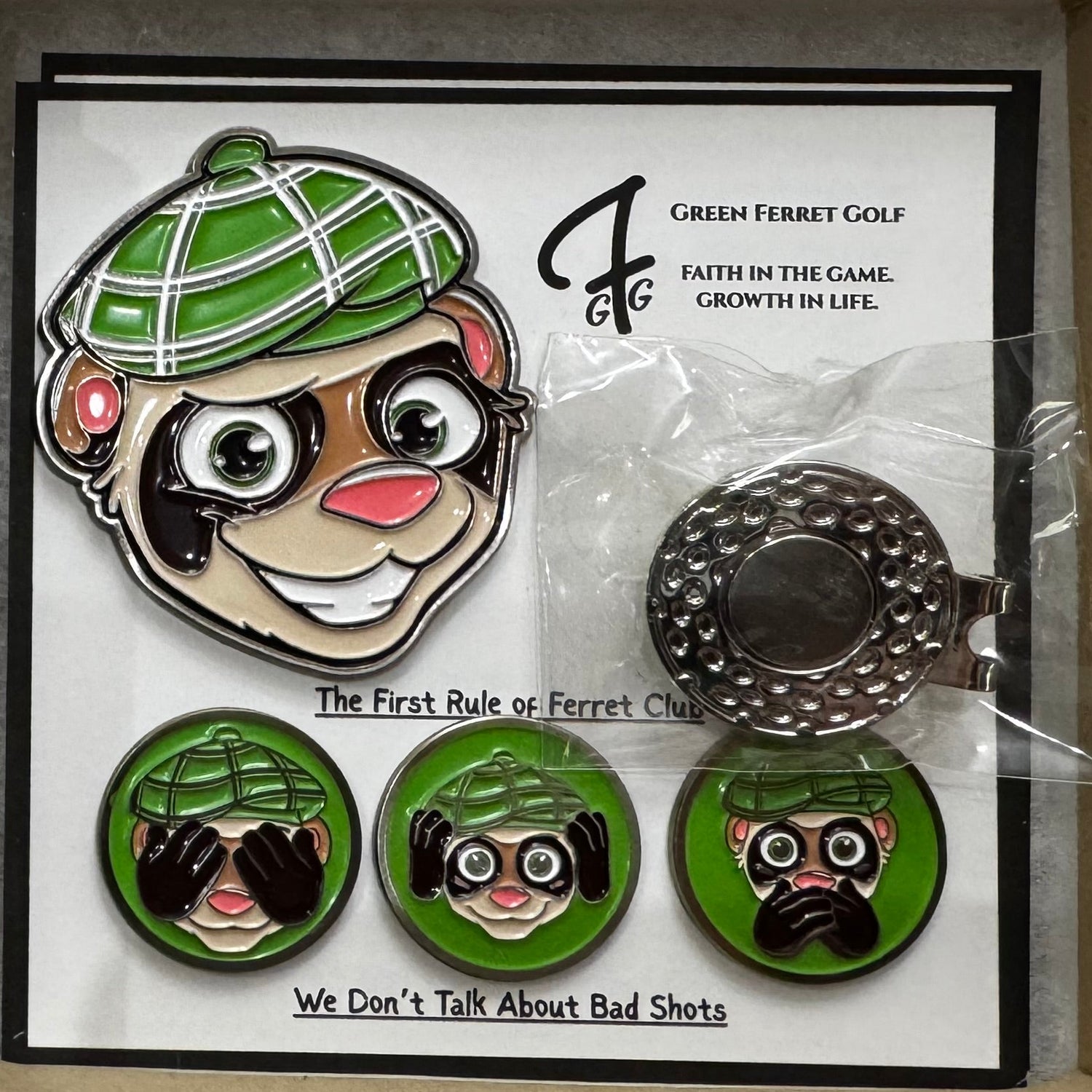Set of ferret-themed pins and a card in a box on a wooden surface