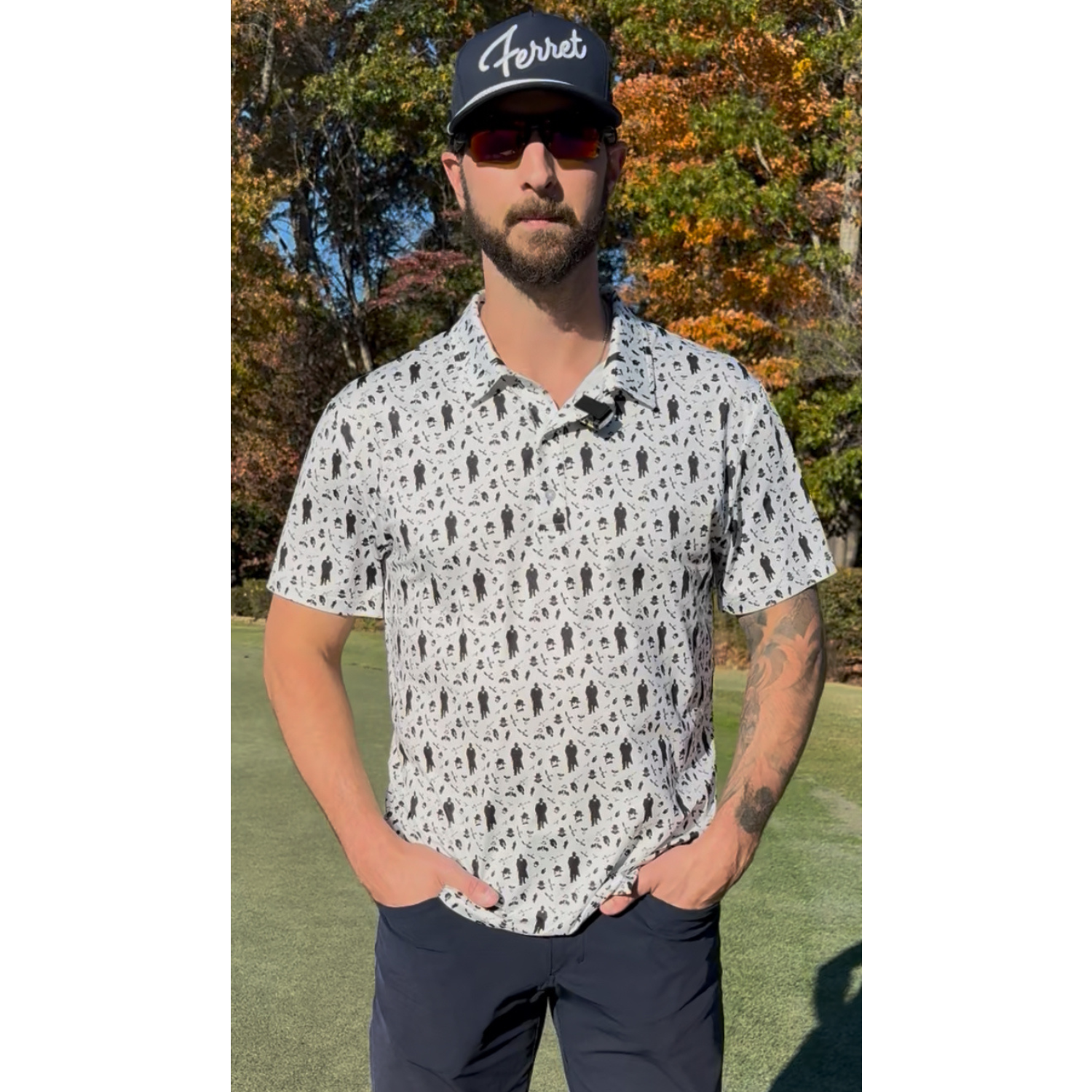 Man wearing a push cart mafia patterned polo from green ferret golf and cap with 'Ferret' logo outdoors.